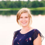 Young blond woman standing in front of a Lake in New Germany.